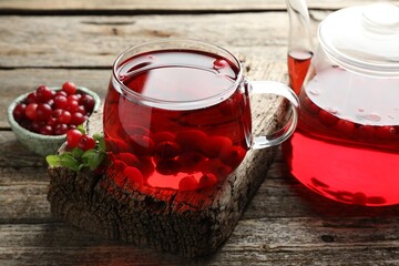 Delicious cranberry tea and berries on wooden table