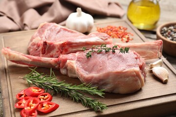 Fresh tomahawk beef cuts and spices on wooden board, closeup