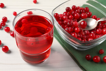Tasty cranberry juice in glass and fresh berries on white wooden table, closeup