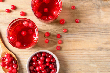 Tasty cranberry juice in glasses and fresh berries on wooden table, flat lay. Space for text
