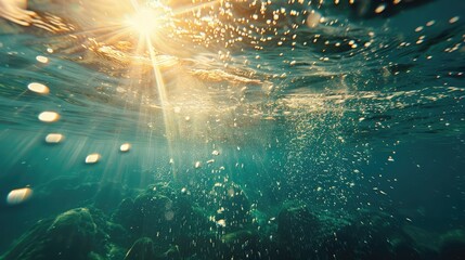 Sunlight underwater with bubbles rising to water surface in the sea