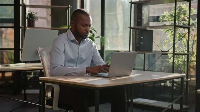 Focused on computer work adult businessman African American senior 40s man worker employer manager specialist programmer typing on laptop at office workplace business middle-aged male data networking
