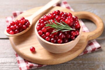 Fresh ripe cranberries and rosemary on wooden table