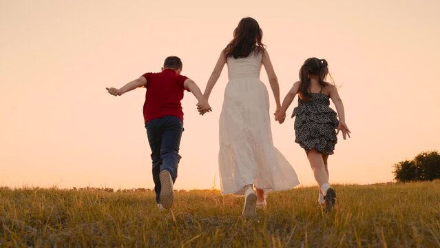 mother runs into sunset holding her son daughter hand, happy family running, boy girl, children run together, holding hands tightly, children playfully participate race with each other, unlimited