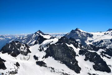 Fototapeta na wymiar View from top of Mount Titlis, Switzerland. Panoramic view on Snow Alps and Blue Sky around Titlis mountain. Urner Alps. Obwalden