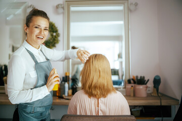 female hairdresser in modern hair studio with hair spray