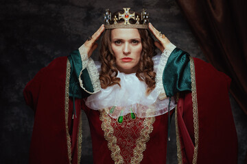 medieval queen in red dress with white collar and crown