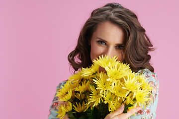 happy woman hiding behind chrysanthemums flowers on pink