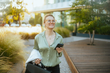 business woman in green blouse and eyeglasses using phone