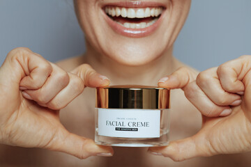 Closeup on woman with cosmetic cream jar