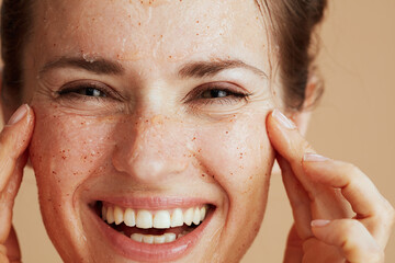smiling young female with face scrub