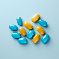 Yellow and blue pills on blue background. Top view with copy space