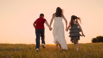 mother runs into sunset holding her son daughter hand, happy family running, boy girl, children run...