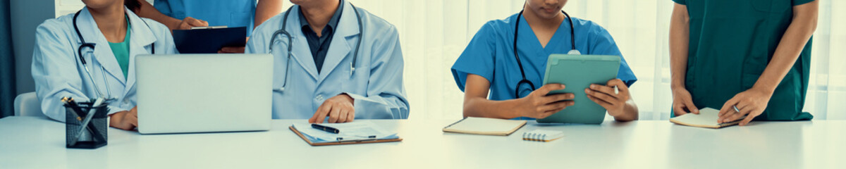Professional various team of medical working and planning medical treatment at hospital table...