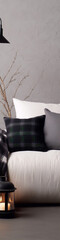 Plaid and neutral pillows on white sofa with gray background and black lamp.
