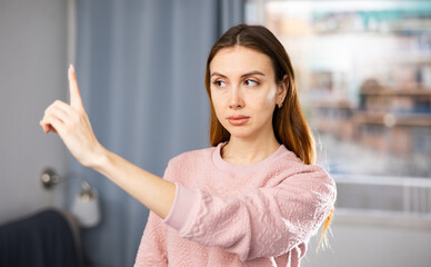 Girl checks her eyesight - carefully looks at her finger. Gymnastics for the eyes