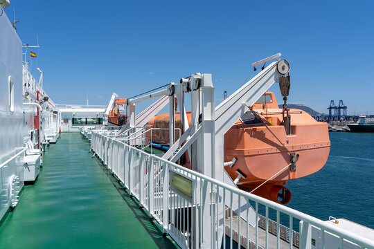 An orange lifeboat raft on a white ferry. High quality photo