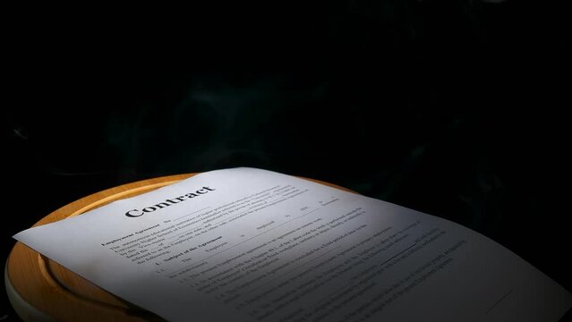 Troubled personal documents on table. A concept of falce paper documents on the table in smoke against black background.