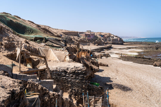 Small makeshift houses in dry climate by the ocean. High quality photo.