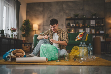 one man young adult recycle at home sort waste plastic paper and glass