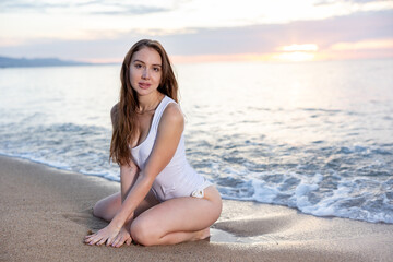 Fototapeta na wymiar Portrait of pretty girl playfully posing on the sandy beach