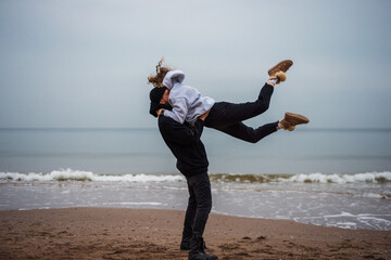 Couple making an acrobatic element at the sea - 739586195