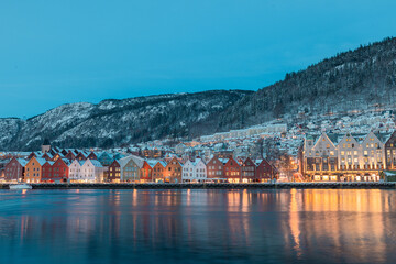 Fototapeta na wymiar Beautiful evening panorama of Bergen waterfront, Bryggen area. Magical cityscape at night, visible colorful houses of Bergen. Long exposure, lights on houses are lit.