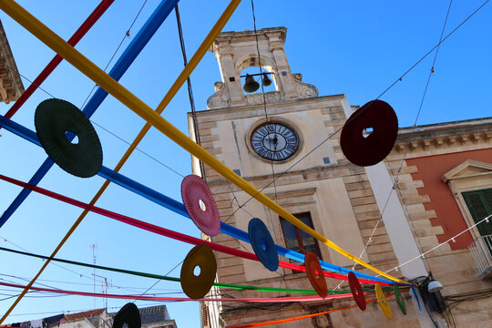 Clock tower in the historic center of Putignano, adorned with festoons for the carnival. Puglia, Italy