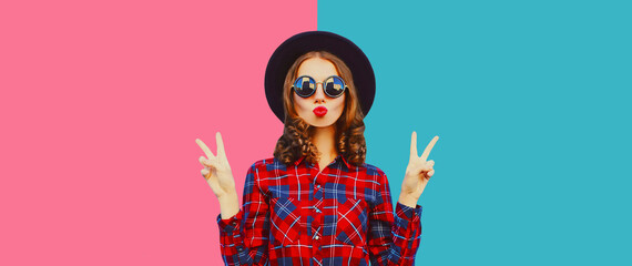 Stylish modern young woman blowing kiss posing on colorful background