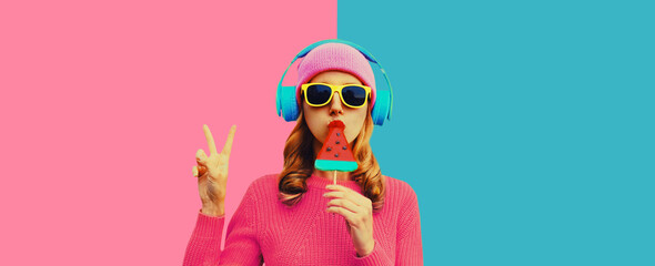 Stylish cool young woman in headphones listening to music on colorful background