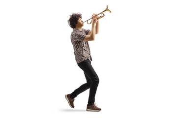 Full length profile shot of a young man walking and playing a trumpet © Ljupco Smokovski