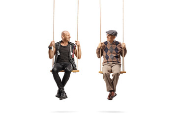 Punk and an elderly man sitting on swings and looking at each other
