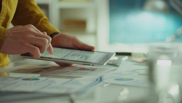 In an authentic office space, creative employee actively uses a touchpad to generate creative ideas. Introduces modern technologies for data analysis and analytics, ideas are based on facts and trends