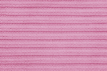 Jersey textile background , pink striped knitted fabric. Woolen knitwear, sweater, pullover surface texture, textile structure, cloth surface, weaving of knitwear material. Wallpaper, backdrop.