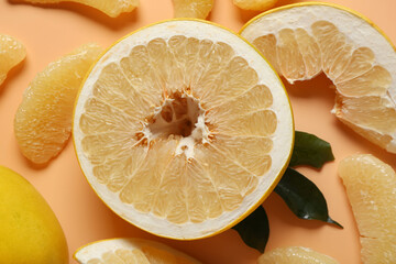 Half of sweet pomelo fruit and slices on beige background