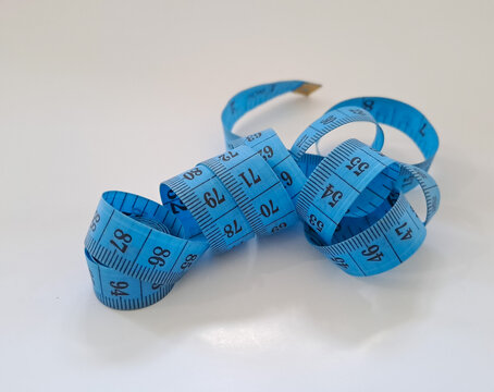Meter tape. Blue measuring tape curls on a white background isolated. Tailor's sewing cloth measuring tool. Ruler for body measuring.
