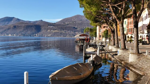 Beautiful Old Town with Trees and Building and Boat on the Waterfront To Lake Lugano with Mountain in a Sunny Day in Morcote, Ticino, Switzerland, Europe