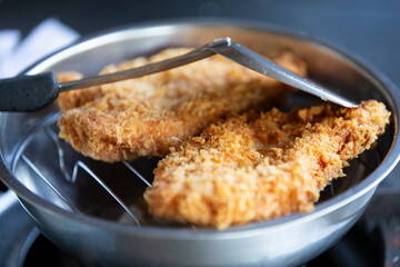 Fried chicken in a pan, close-up, selective focus