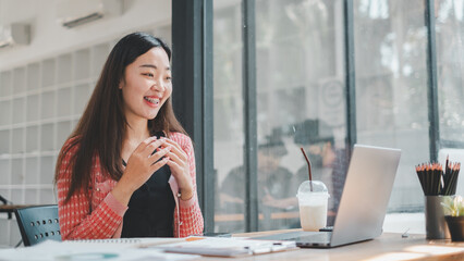 Business analytics concept, A happy young woman with braces is seen enjoying her work on a laptop...