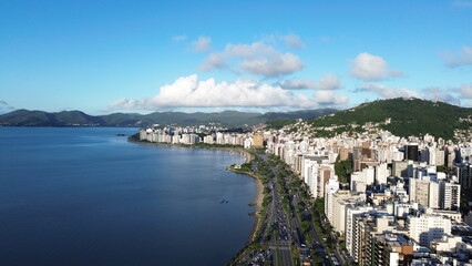 Fototapeta premium Imagem aérea da beira-mar norte da capital Florianópolis com prédios, mar calmo e carros estacionados.