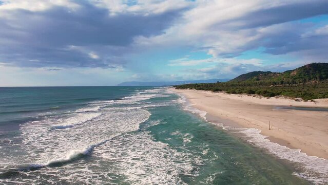 Aerial drone view on white sand Berchida beach of Sardegna. Warm turquoise sea and long beach on the Sardinia island.