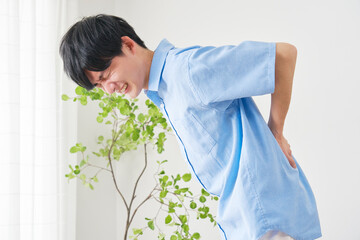 リビングでぎっくり腰で腰が痛い男性