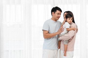 Fototapeta premium father and mother holding and hugging with toddler baby on white window background. happy family