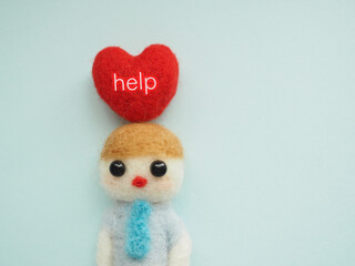 羊毛フェルトの男性のハートにhelpヘルプの文字　コピースペース