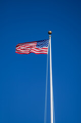 American Flag on a White Flag Pole in Strong Wind.