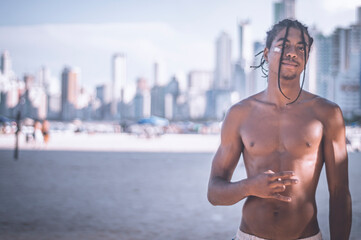 17-year-old Afro-descendant teenager with braids in his hair and no shirt, various facial expressions, city of Balneário Camboriu in the background is blurred