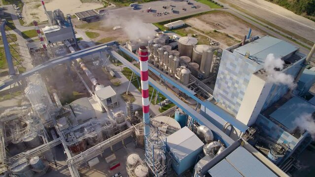 Aerial tilt-down shot of a big industrial plant on a sunny day - bird's eye view of a modern cellulose factory