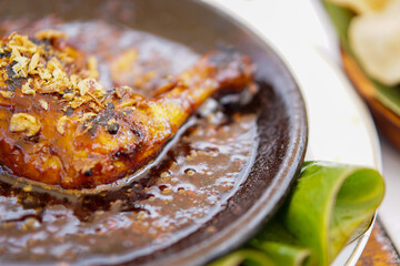 close-up grilled chicken with spicy sambal served on a cobek.