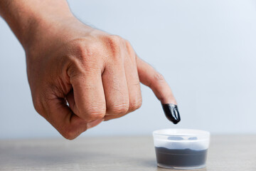 A man's little finger dipped in ink after voting in the Indonesian presidential election - obrazy, fototapety, plakaty