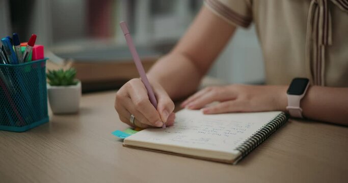 Footage steady shot,Selective focus, Hands of Young asian woman sitting at desk holding pen making notes in diary at home, creative thoughts to journaling, idea and inspiration